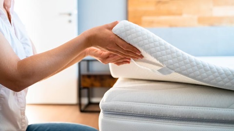 vrouw tilt topmatras boven matras op